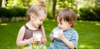 Due bambini bevono latte