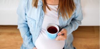 donna incinta con tazza di caffè