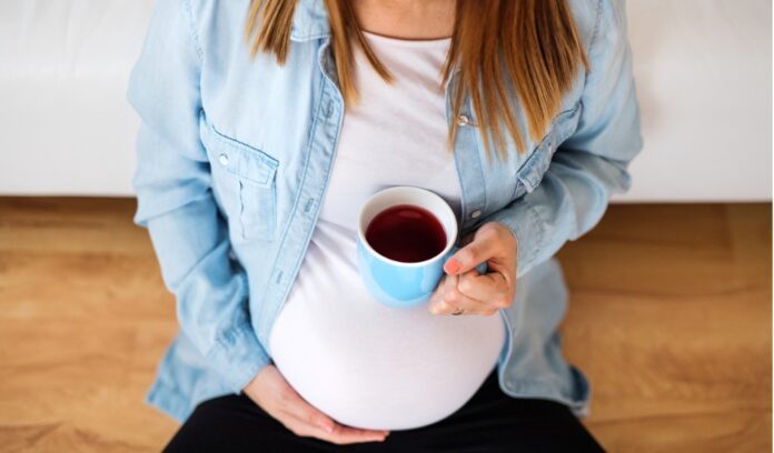 donna incinta con tazza di caffè