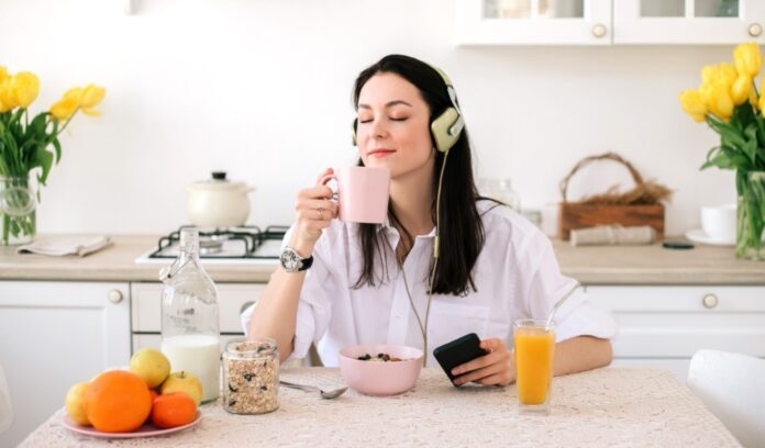 ragazza colazione beve tazza caffè ascolta musica