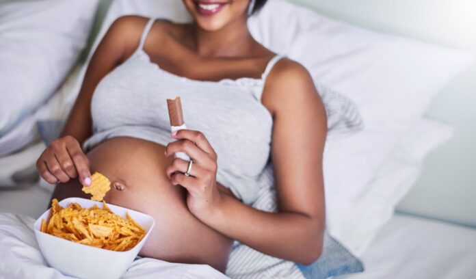donna incinta mangia snack