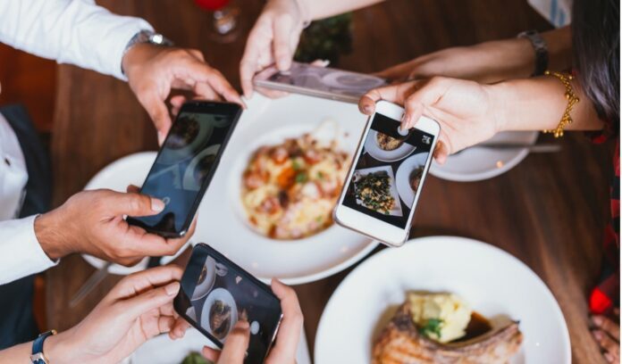 gruppo amici telefoni foto piatti cibo