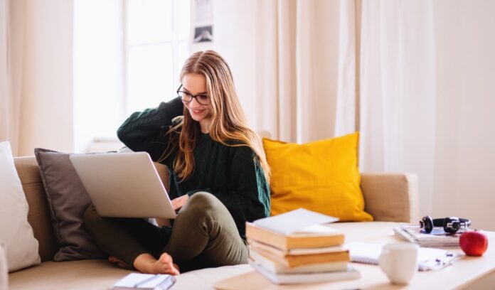 giovane ragazza studia seduta sul divano