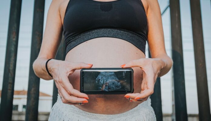 Donna incinta mostra ecografia dal cellulare
