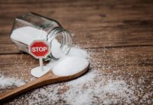 Barattolo di zucchero rovesciato con un segnale di STOP a indicare la limitazione dello zucchero