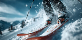 Dettaglio dinamico di una discesa con gli sci che alzano nuvole di neve in alta montagna.