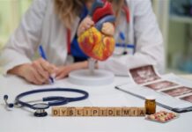 Medico alla scrivania e scritta "Dislipidemia" con dei blocchi di legno sulla scrivania